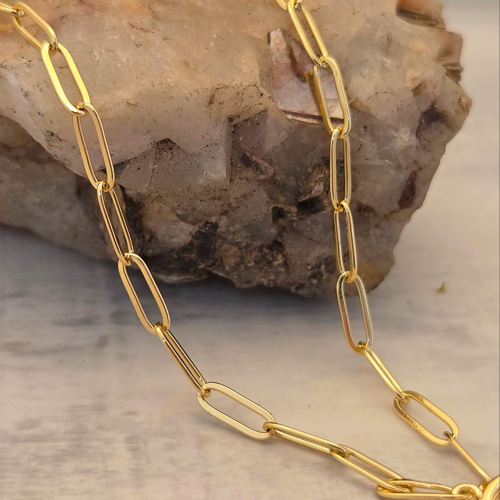 Gold paperclip chain laying across a rock