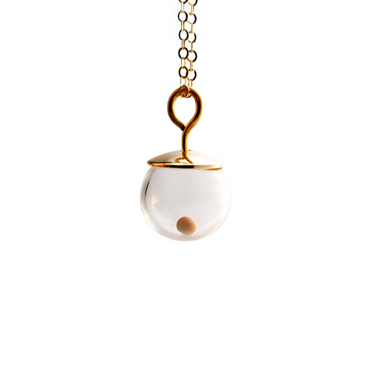 Close-up of a Tiny 14K gold-filled mustard seed necklace against a white background, featuring a single real mustard seed enclosed in a clear 8mm hand-blown glass globe with a polished gold-filled cap and a handmade 3mm loop, suspended from a delicate gold-filled cable chain.